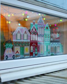 an image of a window with christmas decorations on it's windowsill and lights in the background