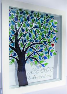 a tree with hearts painted on it in a white frame