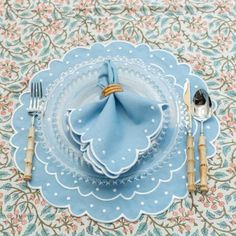 a place setting with blue napkins and silverware