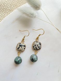 "These are small, lightweight, gemstone drop earrings featuring square Dalmatian Jasper connectors, and a 10mm African Turquoise pendant bead. These cute and unique dangle earrings hang approximately 2.0\" inches from the lobe. The earwire is 18k gold plated and should be suitable if you have a metal allergy or sensitivity. These earrings are very lightweight and comfortable for all-day wear. If you are not satisfied with your purchase, contact me within 14 days, and return your earrings in the Rectangular Jewelry With Dangling Beads For Gifts, Gift Jewelry With Dangling Rectangular Beads, Unique Dangle Earrings, Gemstone Drop Earrings, Dalmatian Jasper, African Turquoise, Earrings Turquoise, Earrings Bohemian, Turquoise Pendant