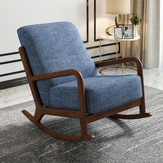 a blue rocking chair sitting on top of a rug in a living room next to a window