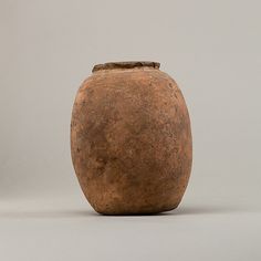 an old brown vase sitting on top of a table