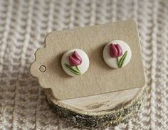 two pink tulips are sitting on top of a piece of wood