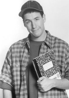 a black and white photo of a man in plaid shirt holding a book with his hands