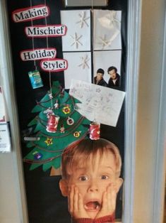 a child's face is hanging on the front door with christmas decorations around it