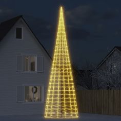 a lighted christmas tree in front of a house