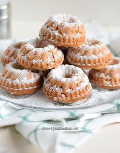 a pile of powdered donuts sitting on top of a plate