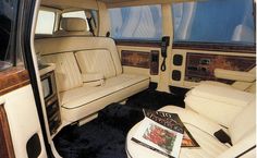 the interior of a car with white leather seats and black rugs on the floor