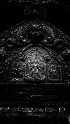 black and white photograph of an intricately carved metal door with carvings on the front