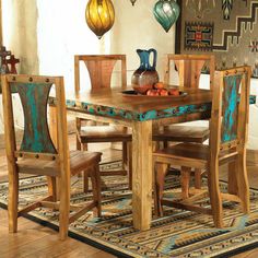 a dining room table with chairs and a rug on the floor in front of it