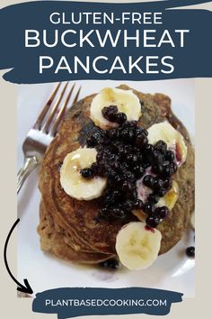 a white plate topped with pancakes covered in blueberries and banana slices next to a fork