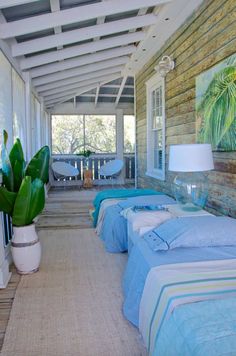 two beds are sitting on the porch next to each other with blue sheets and pillows