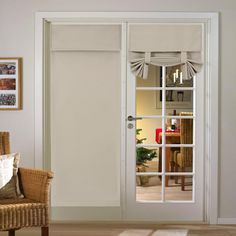 an open door with curtains on the side and a wicker chair next to it