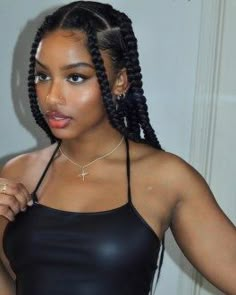 a woman wearing a black top and braids