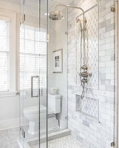 a white bathroom with a walk in shower next to a toilet