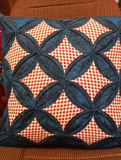 a blue and red pillow sitting on top of a chair