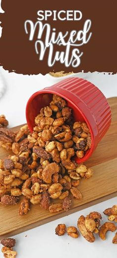 spiced mixed nuts in a red container on a cutting board with text overlay