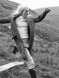 black and white photograph of a woman running in the mountains with her arms outstretched,