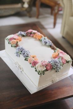 a white cake with flowers on it sitting on a table