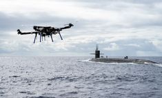 a small submarine in the middle of the ocean with an airplane flying over it's head