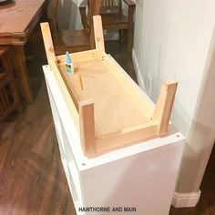 an unfinished kitchen sink in the middle of a room with wooden floors and chairs around it