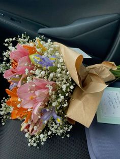 a bouquet of flowers sitting on top of a car seat