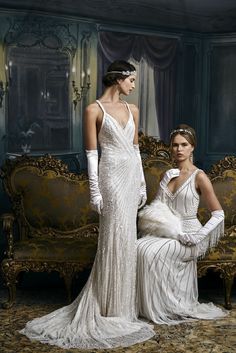 two women in white dresses sitting on a couch