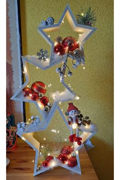 a christmas tree made out of star shaped ornaments with lights on the top and bottom