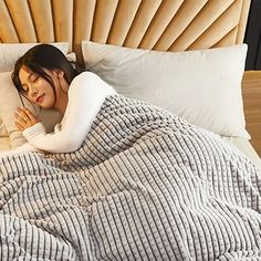 a woman is laying in bed with her head on the pillow and covering her face