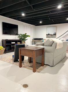 a living room filled with furniture and a flat screen tv mounted on the wall above it