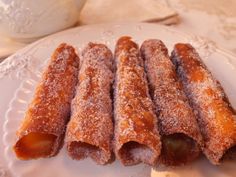 several pastries on a white plate with powdered sugar