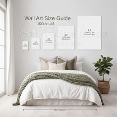 a bed with white sheets and pillows in front of a wall art size guide poster