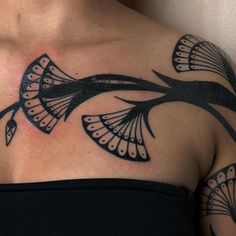 a woman with tattoos on her chest and shoulder