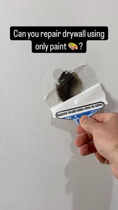 a person holding a toothbrush in their left hand with the words can you repair drywall using only paint?