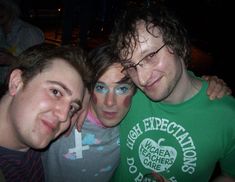 three men are posing for the camera with their arms around each other while one man has his face painted