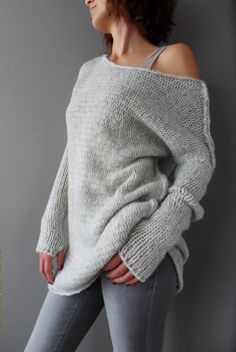 a woman is wearing a sweater and jeans