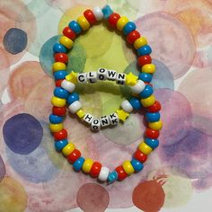 This listing is for a set of two Kandi bracelets; both are clowncore inspired. Perfect for the silly goose in you! Both are very similar, using a blue star as an anchor bead with a continuous pattern of beads in bright primary colors, and have yellow star-shaped beads either side of 'clown' or 'honk' respectively. ♡IMPORTANT INFO BELOW!♡ ☆I create each one with stretchy beading string, with meticulously tied knots sealed with super glue, ensuring durability and to prevent unraveling over time. ☆The bracelets are made to fit the average circumference of a wrist (7.5"), but each one varies in size due to the nature of being handmade. ☆Free Shipping in the U.S. ☆This shop is solely run by me, an autistic + chronically ill trans man. I appreciate you taking your time to support me and my art & Pony Bead Bracelets Words, Bracelet Background, Clown Bracelet, Funny Bead Bracelets, Cool Bracelets Ideas, Kandi Inspiration Pony Beads, Kidcore Kandi, Pansexual Bracelet, Trans Bracelet