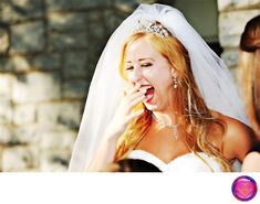 a woman in a wedding dress is eating something out of her mouth while another woman looks on