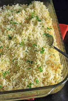 a glass casserole dish filled with rice and garnished with green onions