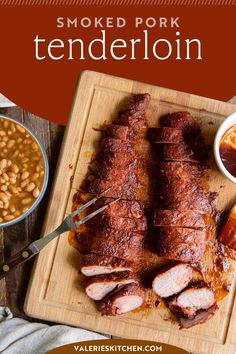 smoked pork tenderloin on a cutting board with beans and sauce