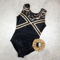 a black and gold leotard swimsuit next to a doughnut