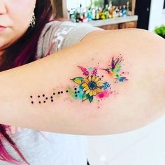 a woman's arm with colorful flowers and dots on the left side of her arm