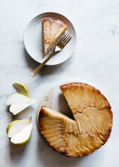 a piece of pie on a plate next to an apple and another slice with a fork