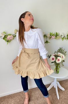 a woman standing in front of a table with flowers on it and looking up at the sky