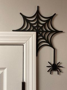 a spider web hanging on the wall next to a white door with a black frame