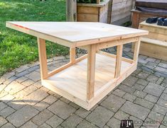 a wooden table sitting on top of a brick patio