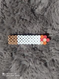 the beaded bracelet is made from white and orange beads with holes on each side