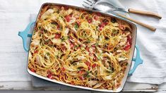 a casserole dish with chicken and noodles in it on a white tablecloth