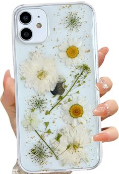 a woman's hand holding an iphone case with white flowers on the front and back