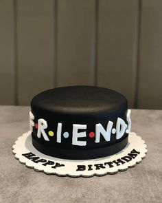 a black birthday cake with the word friend on it's side and happy birthday written across the top